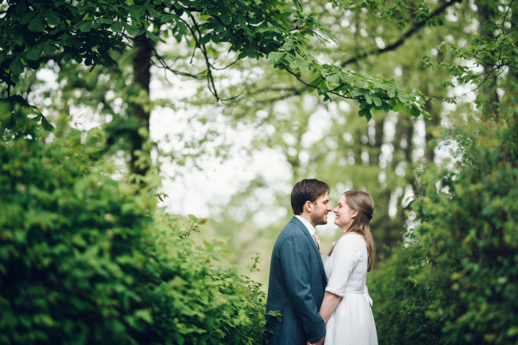 Bryllupsfoto av brud og brudgom i Frognerparken. De ler og stemningen er romantisk.