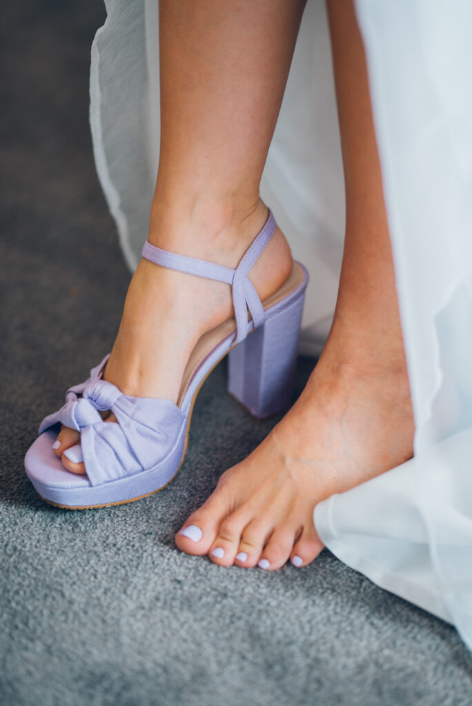 Nærbilde av brudens lilla sko. Hun forbereder seg til vielsen på Gran Hotell.
